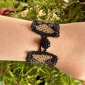 Woven wide seed bead cuff bracelet in black/gold diamond pattern w/knot closure.
